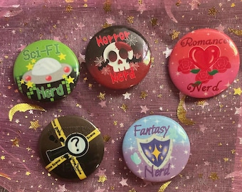 May include: Five colorful round buttons with the words "Sci-Fi Nerd", "Horror Nerd", "Romance Nerd", "Mystery Scene", and "Fantasy Nerd". The buttons feature illustrations of a UFO, skull, heart and roses, magnifying glass, and shield.