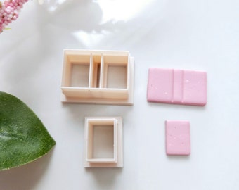 May include: A set of four white plastic molds for making miniature furniture. The molds are in the shape of a sofa, a chair, and two rectangular pieces. The molds are on a white surface.