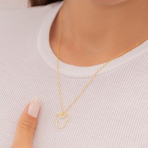 May include: A gold chain necklace with a Mickey Mouse head pendant.