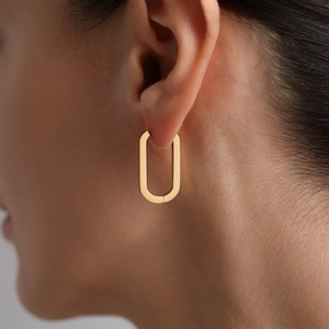 May include: Gold oval hoop earrings. The earrings are simple and elegant, and they would be a great addition to any jewelry collection.