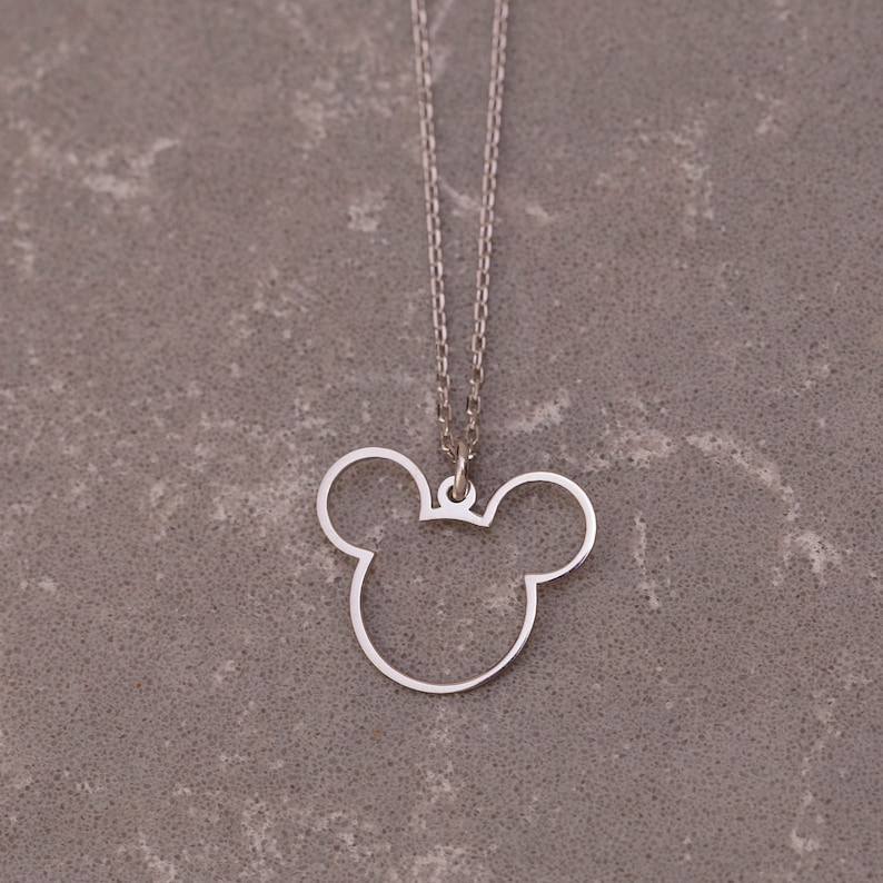 May include: A silver chain necklace with a pendant shaped like a Mickey Mouse head.