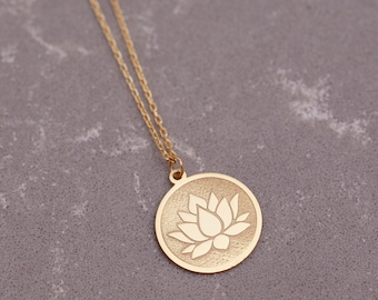May include: A gold chain necklace with a round pendant featuring a detailed lotus flower design.