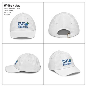 May include: White youth baseball cap with the embroidered text "BAD DAY TO BE A Blueberry" in blue. The cap is a six-panel design and one size fits all.