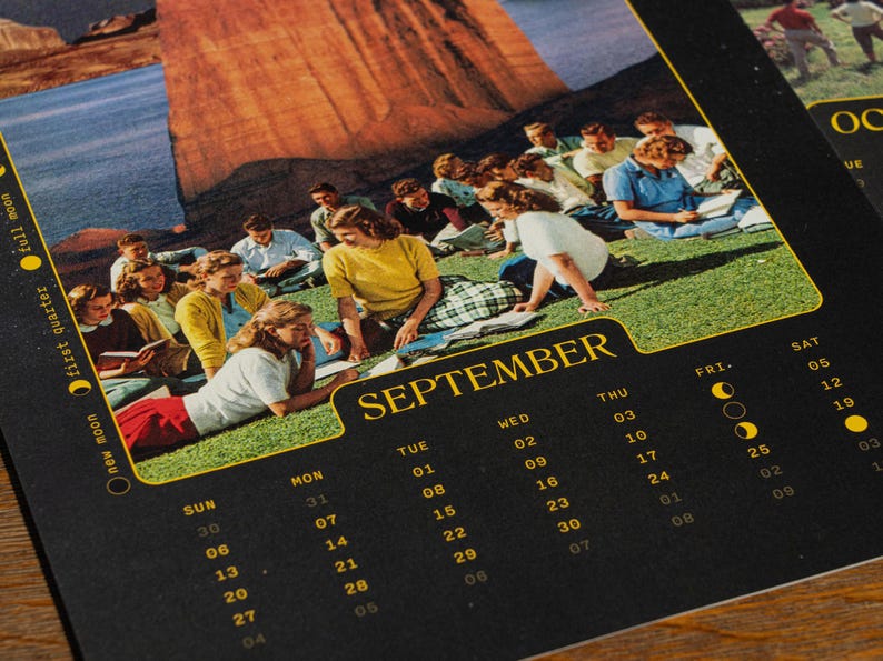 Pu&ograve; includere: Una pagina del calendario di settembre con una fotografia vintage di un gruppo di persone sedute su una collina erbosa vicino a una grande formazione rocciosa. La griglia del calendario &egrave; stampata in giallo su uno sfondo nero.