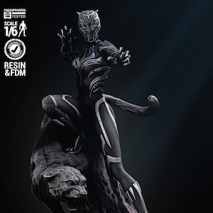 Può includere: Statua dettagliata di Black Panther nera e argento in posa dinamica, appollaiata su una base scolpita con una testa di pantera. La figura è una miniatura in resina e FDM in scala 1/6.