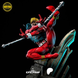 Puede incluir: Una figura de acci&oacute;n roja y azul de un superh&eacute;roe en una pose din&aacute;mica, sosteniendo un arma. La figura est&aacute; de pie sobre una base de piedra con un brillo azul y verde. La figura est&aacute; etiquetada como "Epic Plus Exclusive".