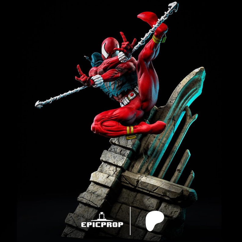 Puede incluir: Una figura de acci&oacute;n roja y azul de un superh&eacute;roe con un dise&ntilde;o de telara&ntilde;a en el pecho, sosteniendo un arma. La figura est&aacute; en una pose de acci&oacute;n din&aacute;mica, de pie sobre una base de piedra. La figura es parte de una serie coleccionable.