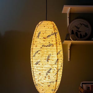 Handmade Lokta paper lamp shade with bamboo frame – eco-friendly Japanese-style lighting. Cylindric Pendant in Large variation paper lantern – Asian-inspired handcrafted light. Hanging Handmade Nepalese Lokta Paper Lamp Shade with Bamboo Frame - Sustainable, Durable, Lightweight. Minimalist Asian-Inspired Design. Embossed Petals, Leaves. Perfect for Home Décor. Unique Shapes: Cylindrical, Abstract, Accordion Hexagon, Globe.