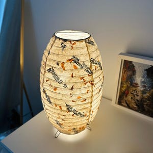 Handmade Lokta paper lamp shade with bamboo frame – eco-friendly Japanese-style lighting.	Tabletop bamboo and Lokta lamp – eco-conscious lighting option. Neutral tone paper pendant light – perfect for Japandi and zen-inspired interiors. Lamp shades in assorted sizes – minimalist home decor. Handmade Nepalese Lokta Paper Lamp Shade with Bamboo Frame - Sustainable, Durable, Lightweight. Embossed Petals, Leaves. Perfect for Home Décor. Unique Shapes: Cylindrical, Abstract, Accordion Hexagon, Globe.