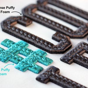 May include: Close-up of embroidered patches in various shapes. Some are dark brown, resembling the letter "J", while others are turquoise, resembling a hashtag symbol. The patches have a textured, puffy appearance, suggesting a raised embroidery technique.