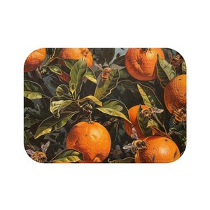 May include: Rectangular decorative mat featuring a vibrant illustration of oranges on a tree with green leaves and bees. The oranges are a bright orange color, and the bees are detailed with black and yellow stripes. The background is a dark green.