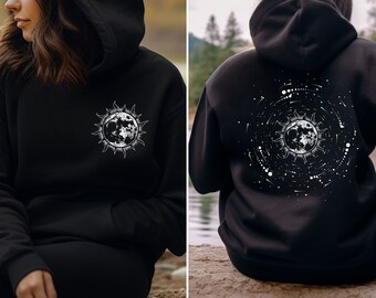 Peut inclure: Sweat-shirt noir avec un motif blanc de lune et de soleil sur le devant et un motif blanc de lune et de soleil avec des étoiles au dos.