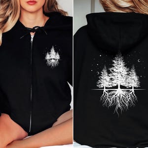 May include: Black zippered hoodie with a white graphic of three trees with roots and stars on the back. The front of the hoodie has a smaller version of the graphic on the left chest.