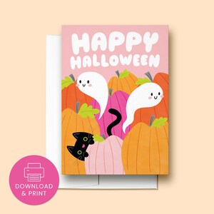 May include: A pink card with the text "Happy Halloween" in white. The card features a black cat peeking out from behind a pile of orange and pink pumpkins. Two white ghosts with smiling faces are floating above the pumpkins.