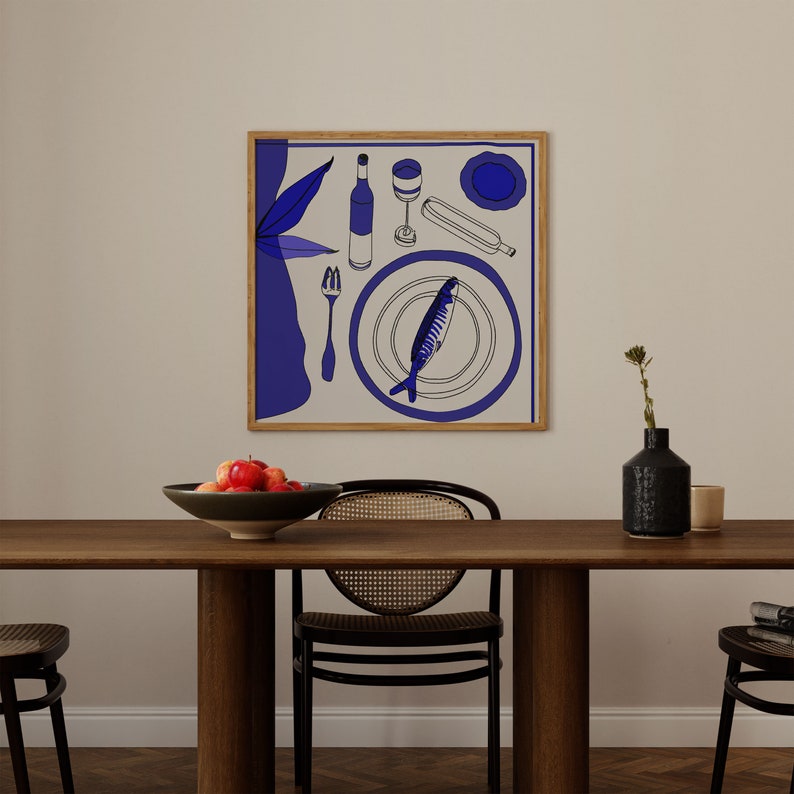 May include: A framed illustration of a blue and white dinner plate with a fish, a wine bottle, a wine glass, and a fork. The illustration is on a white background and is framed in a light brown frame. The frame is hanging on a white wall.