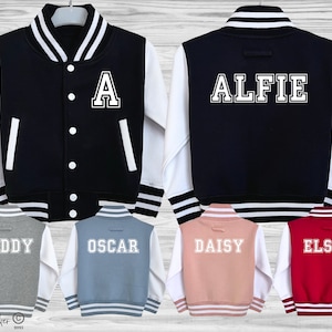 May include: Five different color varsity jackets with white sleeves and contrasting colored bodies. The jackets have a white letter or name on the back. The jackets are: grey with "Teddy", blue with "Oscar", pink with "Daisy", red with "Elsie", and black with "Alfie".