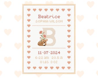 May include: A framed cross-stitch birth announcement with the name "Beatrice" and birth details. The design includes a deer with flowers, a large letter "B", and a border of hearts. The birth details include the date, time, length (20.5 inches), and weight (8 lbs 3 oz).