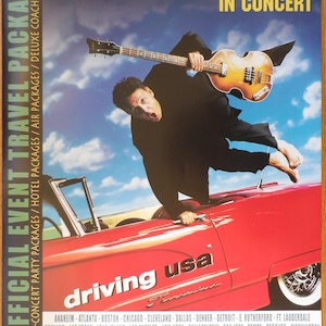 Peut inclure: Une affiche annonçant une tournée de concerts de Paul McCartney. L'affiche présente une photo de Paul McCartney sautant sur une voiture rouge tout en jouant de la basse. Le texte sur l'affiche indique "Paul McCartney en concert" et "Driving USA". L'affiche comprend également une liste des villes où la tournée aura lieu et un numéro de téléphone à appeler pour les billets.
