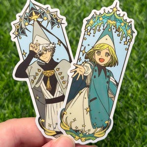Könnte beinhalten: Zwei Aufkleber mit Anime-Illustrationen von Charakteren in aufwendigen Outfits. Eine Figur trägt ein weißes und graues Outfit mit einer schwarzen Augenklappe. Die andere Figur trägt ein türkis-weißes Outfit. Beide Aufkleber haben einen hellblauen Hintergrund.