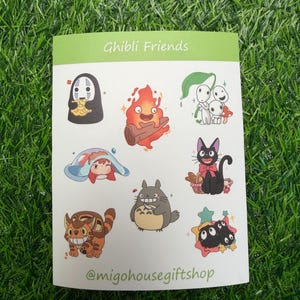 Może przedstawiać: Arkusz naklejek z r&oacute;żnymi postaciami z film&oacute;w studia Ghibli. Naklejki zawierają postacie takie jak No-Face, Calcifer i Totoro. Tekst "Ghibli Friends" znajduje się na g&oacute;rze, a nazwa użytkownika Instagram sklepu na dole.