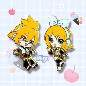 May include: Two enamel pins depicting anime-style characters with yellow hair and blue eyes. One pin is a male character, the other a female character. Both are wearing black and gold outfits. The word "Migo" is written in the image.