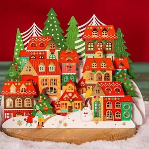 TARJETA POPUP - Tarjeta de felicitación de pueblo navideño con muñeco de nieve y casas decoradas - Diseño cortado a láser con sobre
