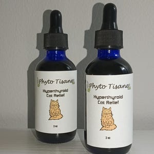 May include: Two 2-ounce bottles of Phyto Tisane Hyperthyroid Cat Relief. The bottles are blue with white labels and feature a cartoon cat illustration.