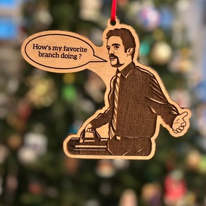 May include: Wooden Christmas ornament featuring a cartoon illustration of a man holding a briefcase and a speech bubble that says "How's my favorite branch doing?"