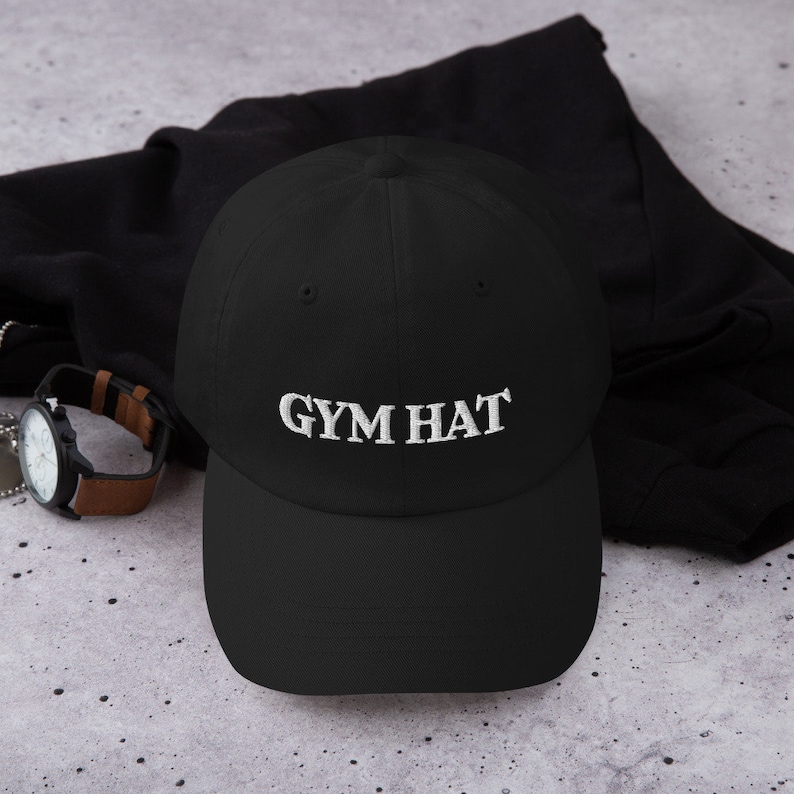 May include: A black baseball cap with a white embroidered design that says "GYM HAT".