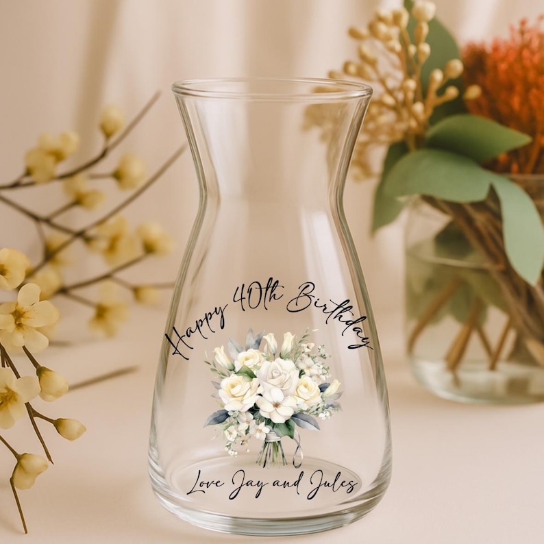 Pode incluir: Um vaso de vidro transparente com um design de buqu&ecirc; floral e o texto "Happy 40th Birthday, Love Jay and Jules." O vaso tem um formato &uacute;nico e &eacute; preenchido com flores.