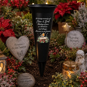 May include: A black conical memorial flower vase featuring the text In loving memory of Mum & Dad, Thinking of you at Christmas and always, Forever in our hearts, and a graphic of a robin perched on a log surrounded by holly and berries.