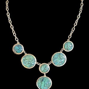 May include: A gold chain necklace with six turquoise blue round pendant stones.