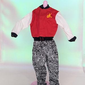 May include: A red and white varsity jacket with black trim and a yellow "gk" logo, paired with black and white patterned pants. The jacket has a black collar and cuffs. The pants have an elastic waistband and cuffs.