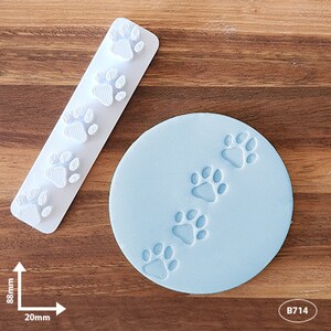 May include: A white rectangular stamp featuring four raised paw prints and a light blue circular disc with four indented paw prints. The rectangular stamp measures 88mm by 20mm. The product is labelled with the code B714.