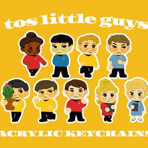 May include: A collection of cartoon character acrylic keychains on a yellow background. The keychains feature various characters in different colored uniforms. The text "tos little guys" and "ACRYLIC KEYCHAINS" are displayed in white.
