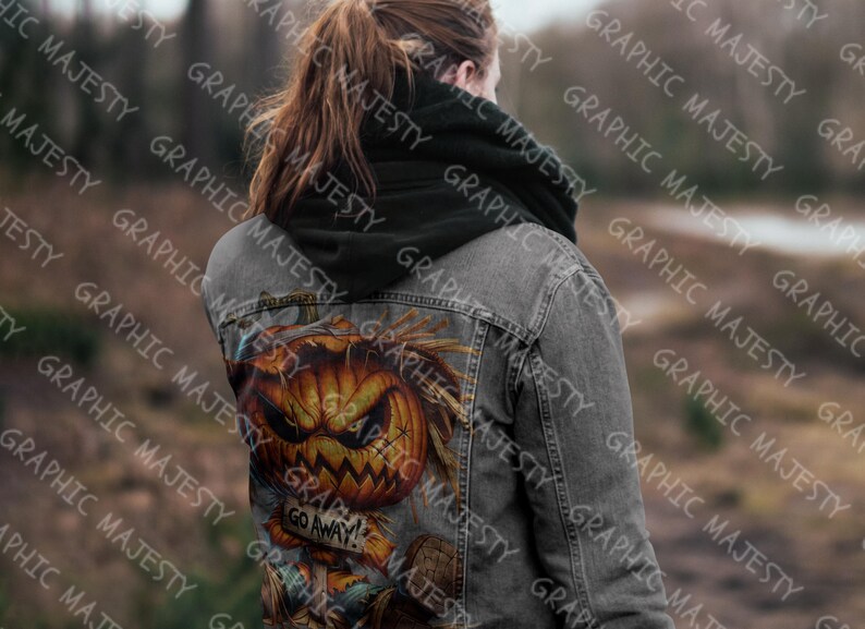 May include: A gray denim jacket with a black hoodie underneath. The back of the jacket features a graphic of a pumpkin with a scary face and the text "Go Away!"