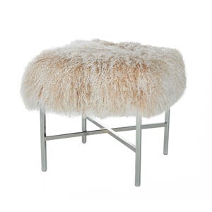 May include: A cream-colored, oval-shaped ottoman with a shaggy, textured top. The ottoman sits on a polished, silver-colored metal frame with an X-shaped support. The legs are straight and square.