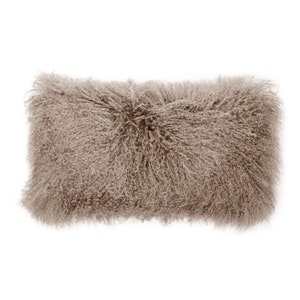 May include: A long, rectangular, light brown sheepskin throw pillow with a fluffy texture.