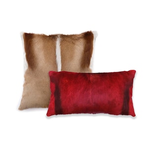 May include: Two decorative throw pillows, one with a brown and white animal print and one with a solid red color.