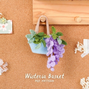May include: A crocheted blue basket with a beige handle, filled with green leaves and a cascade of purple wisteria flowers. The text "Wisteria Basket PDF Pattern" is below the basket.