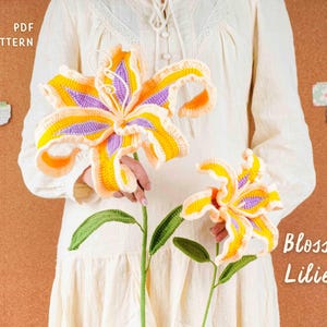 May include: Two crocheted lily flowers in yellow, orange, and purple, with green stems and leaves. The text "Blossom Lilies" is visible. The image also includes the text "PDF PATTERN".