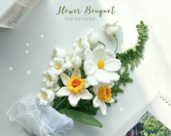 May include: A crocheted flower bouquet with white and yellow flowers and green leaves. The bouquet is wrapped in white tulle and has the text "Flower Bouquet PDF Pattern" at the top.