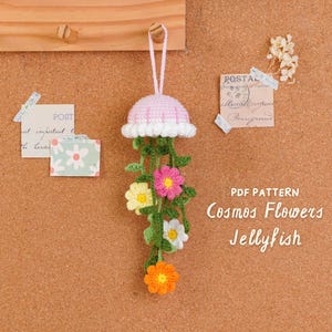 May include: A handmade crochet jellyfish decoration with a pink and white cap, green tendrils, and colorful flower accents. The text "PDF Pattern Cosmos Flowers Jellyfish" is visible.