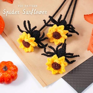 May include: Crocheted spider sunflowers with yellow petals and brown centers, black spider bodies and legs. The text "PDF PATTERN Spider Sunflower" is visible. Decorative pumpkins and fall leaves are in the background.