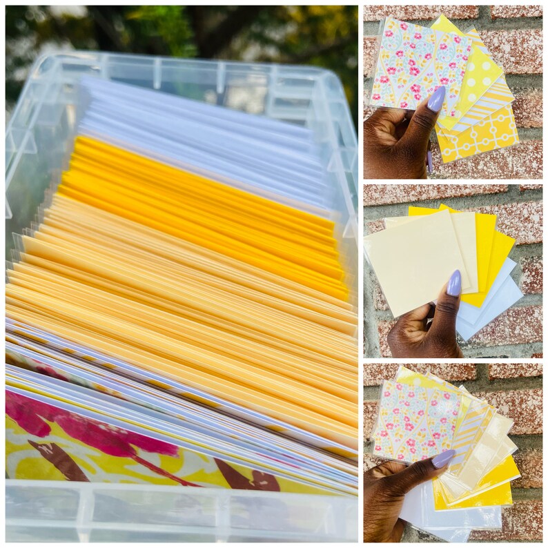 May include: A clear plastic storage container filled with stacks of yellow, white, and patterned paper cards. The cards are arranged in rows and columns. The container is sitting on a table.
