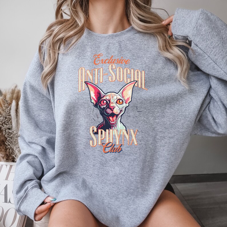 May include: Gray sweatshirt with a graphic of a Sphynx cat with the text "Exclusive Anti-Social Sphynx Club".