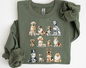 May include: An olive green sweatshirt featuring a watercolor illustration of various dog breeds. The design includes a golden retriever, bulldog, beagle, Dalmatian, Yorkshire terrier, poodle, chihuahua, corgi, border collie, French bulldog, German shepherd, and Pomeranian.