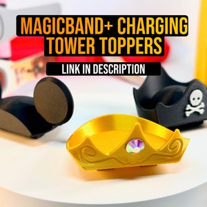 Pode incluir: Tr&ecirc;s toppers impressos em 3D para o carregador MagicBand. Os toppers t&ecirc;m a forma de orelhas do Mickey Mouse, um chap&eacute;u de pirata com uma caveira e ossos cruzados, e uma coroa dourada com uma joia.