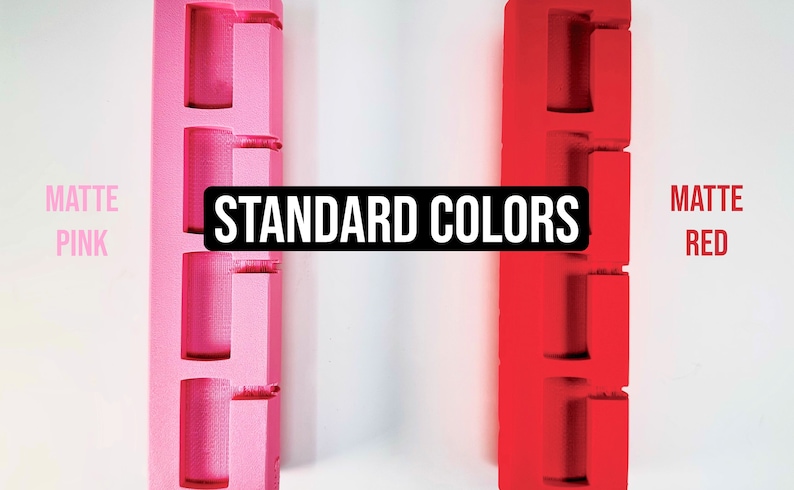 Pode incluir: Dois objetos impressos em 3D, um rosa fosco e outro vermelho fosco, com o texto "STANDARD COLORS" em letras pretas.