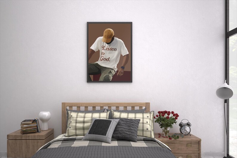 May include: A framed illustration of a person wearing a white t-shirt with the text "Listen to God." The person is wearing a brown hat and sitting on a brown surface.